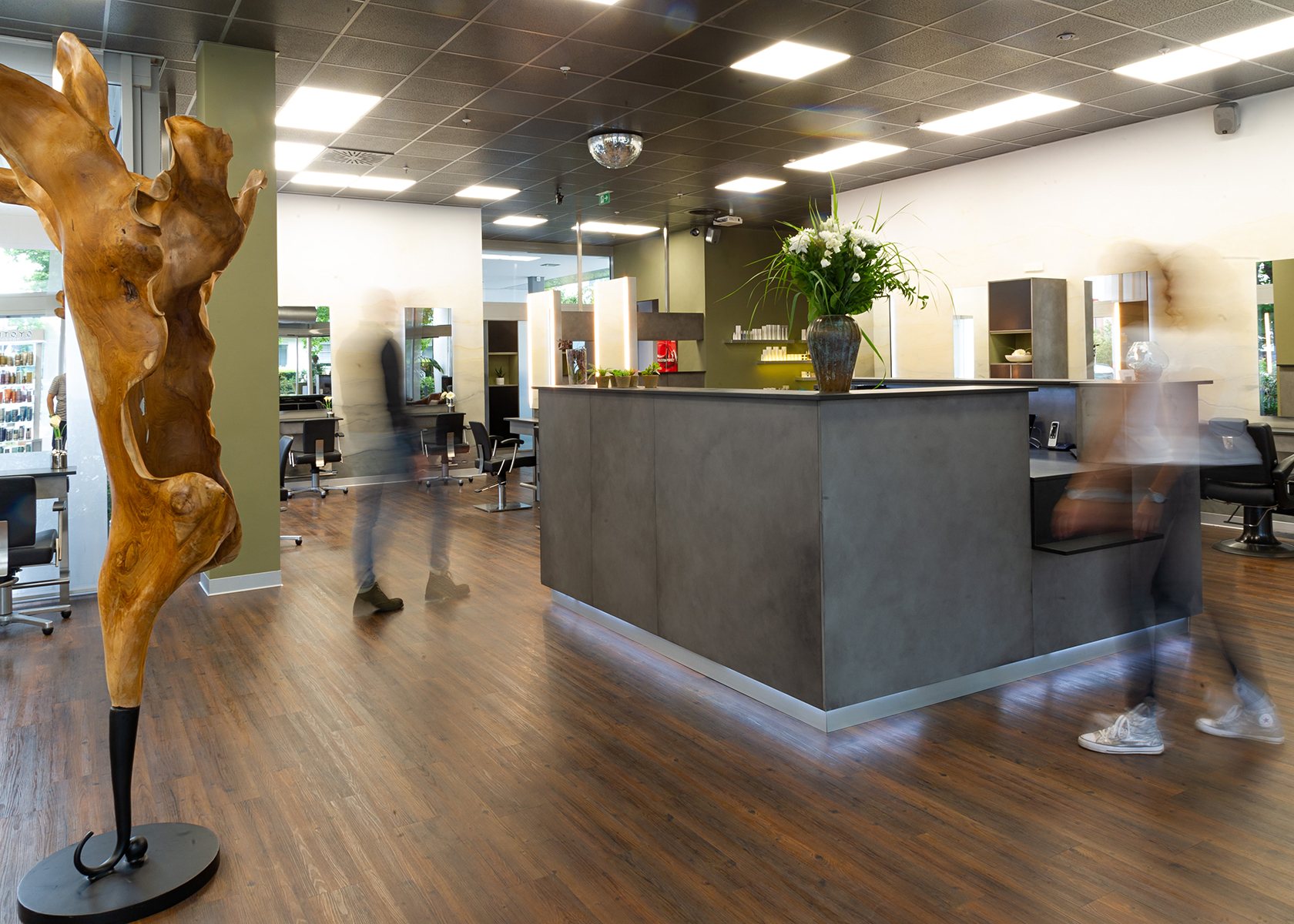 Empfang im Salon HAARE mittmann mit Holzskulptur und Blumen